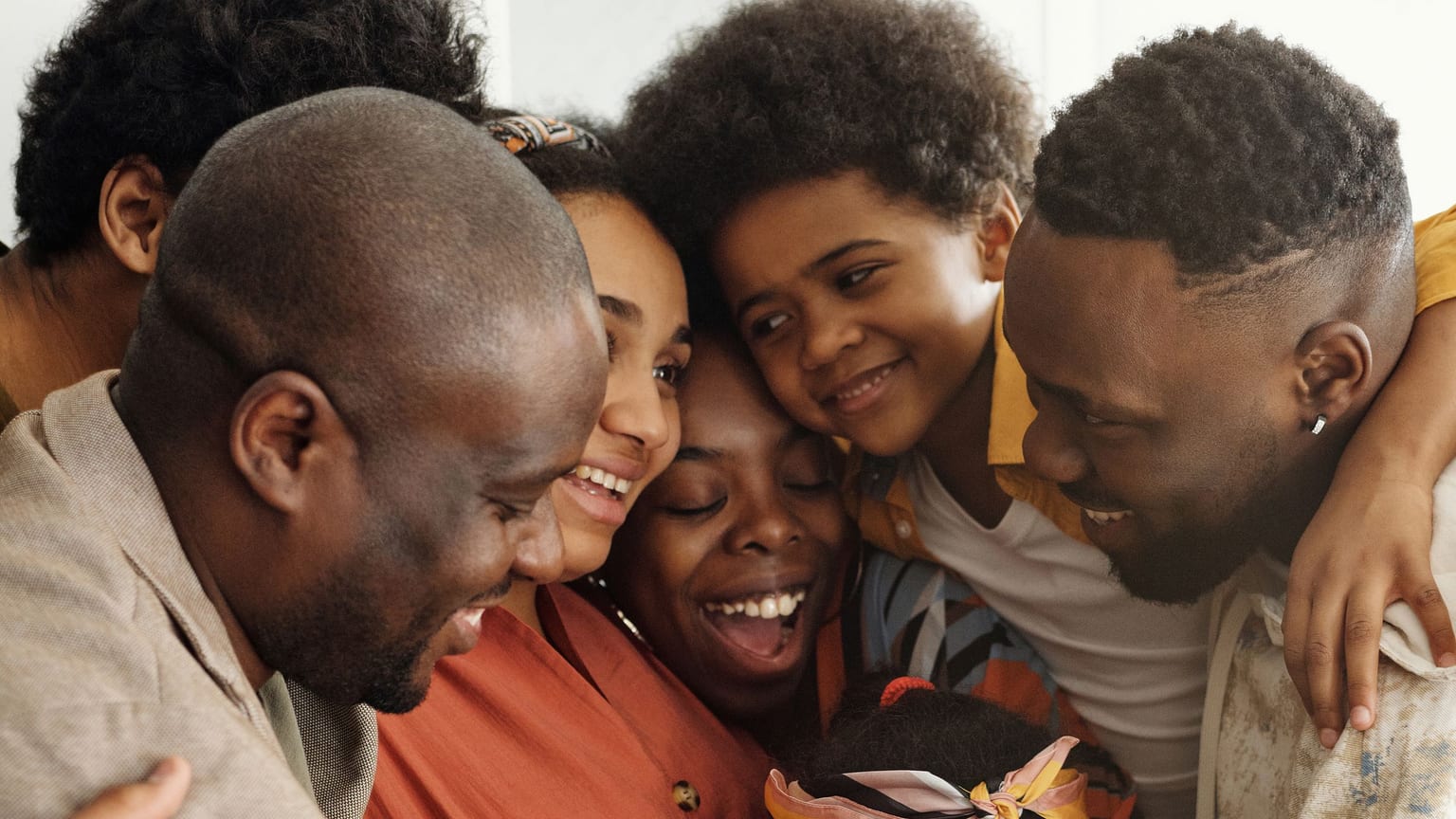 A multi-generational family sharing a close, joyful group hug